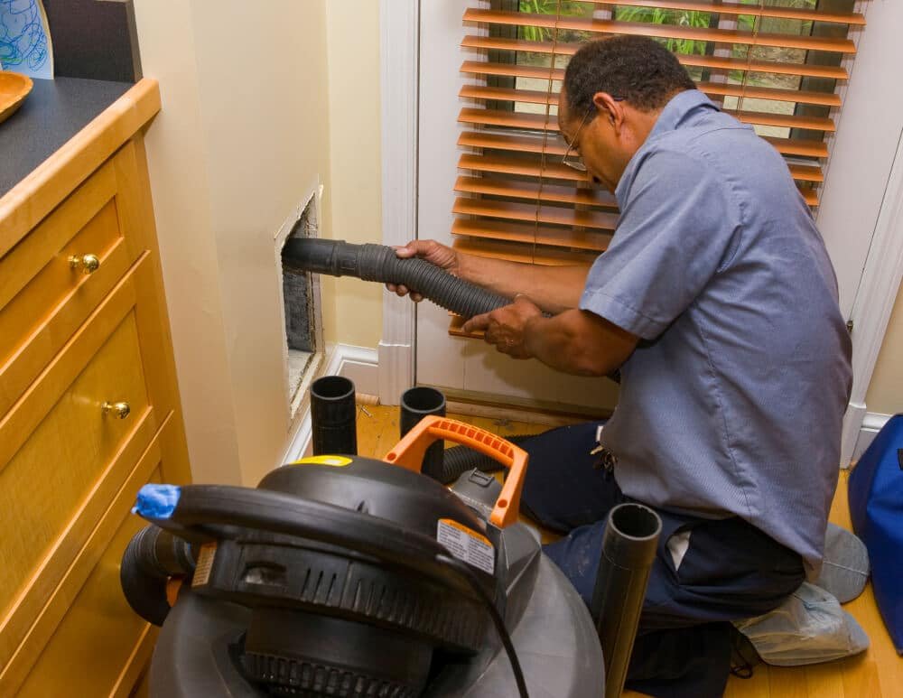 worker cleaning ducts in home