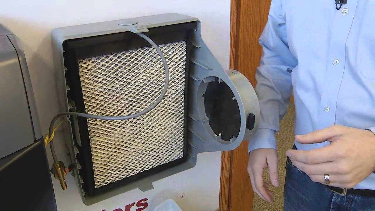 technician changing furnace humidifier filter